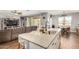 Kitchen island featuring granite countertops, stainless steel sink, and adjacent seating and living area at 30208 W Fairmount Ave, Buckeye, AZ 85396
