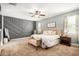 Spacious main bedroom featuring a decorative wall, ceiling fan, and tufted headboard at 30208 W Fairmount Ave, Buckeye, AZ 85396