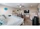 Well-lit bedroom with ceiling fan, mounted TV, and desk setup creating an inviting atmosphere at 30213 W Fairmount Ave, Buckeye, AZ 85396