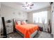 Bedroom features a ceiling fan, large window, and a plush bed with decorative pillows at 30213 W Fairmount Ave, Buckeye, AZ 85396