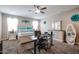 Bright bedroom with large bed, ceiling fan, and convenient desk setup for comfortable living at 30213 W Fairmount Ave, Buckeye, AZ 85396