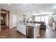 Open concept kitchen features stainless appliances, island with barstool seating, and modern lighting at 30213 W Fairmount Ave, Buckeye, AZ 85396