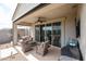 Covered patio with ceiling fan, comfortable seating and sliding doors to inside at 30213 W Fairmount Ave, Buckeye, AZ 85396