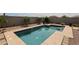 Sparkling backyard pool surrounded by stone and desert landscaping offers privacy at 30213 W Fairmount Ave, Buckeye, AZ 85396