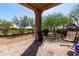 Covered patio with an egg chair and views of the desert-landscaped backyard at 32627 N 70Th St, Scottsdale, AZ 85266