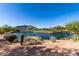 Picturesque view of a serene pond in a golf course community with lush greenery and distant mountain backdrop at 32627 N 70Th St, Scottsdale, AZ 85266