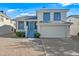 Charming two-story home featuring an attached garage, gravel yard, and a vibrant blue front door at 3365 W Thude Dr, Chandler, AZ 85226
