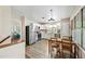 An open kitchen and dining area with wood-look floors and a bright, white kitchen with stainless appliances at 3365 W Thude Dr, Chandler, AZ 85226