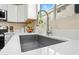 Close-up on modern kitchen sink with white countertop, stainless steel faucet and fruit bowl at 3365 W Thude Dr, Chandler, AZ 85226