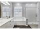 Bright bathroom featuring double sinks, white cabinets, a tub and separate glass shower at 3552 E Dogwood Dr, Chandler, AZ 85286