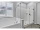 Bright bathroom with white trim featuring a garden tub and glass shower at 3552 E Dogwood Dr, Chandler, AZ 85286