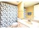Classic bathroom with a floral shower curtain, white fixtures, and ample lighting at 4200 N Miller Rd # 228, Scottsdale, AZ 85251
