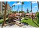 Lush courtyard view with flowering trees, manicured lawn, and a covered outdoor seating area with surrounding palm trees at 4200 N Miller Rd # 228, Scottsdale, AZ 85251
