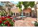 Charming courtyard featuring a tranquil fountain, red flowers, mature trees, and inviting building entrance at 4200 N Miller Rd # 228, Scottsdale, AZ 85251