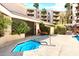Community hot tub with blue tile, lounge chair, and lush greenery, offering a tranquil outdoor space at 4200 N Miller Rd # 228, Scottsdale, AZ 85251