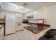 Cozy kitchen with white cabinetry, a breakfast bar, and modern appliances offers functional charm at 4200 N Miller Rd # 228, Scottsdale, AZ 85251
