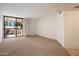 Spacious living room featuring plush carpeting and a sliding glass door to the balcony at 4200 N Miller Rd # 228, Scottsdale, AZ 85251