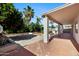 Covered patio leads to a backyard area with mature trees and landscaping at 43232 W Magnolia Rd, Maricopa, AZ 85138