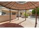 A gazebo surrounded by a patio and green foliage with an outdoor kitchen at 43232 W Magnolia Rd, Maricopa, AZ 85138