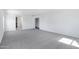 An empty bedroom with neutral walls, gray carpet and views to an ensuite and closet at 43232 W Magnolia Rd, Maricopa, AZ 85138