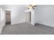 Bright bedroom features neutral carpeting, ceiling fan, and multiple closets and entryways at 43232 W Magnolia Rd, Maricopa, AZ 85138