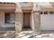 Close-up of front entry with stone pillars, address numbers, and wood door at 43232 W Magnolia Rd, Maricopa, AZ 85138