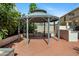 View of the backyard gazebo on a terracotta-stamped concrete patio surrounded by green shrubs at 43232 W Magnolia Rd, Maricopa, AZ 85138