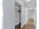 Bright hallway with hardwood floors and a storage closet with sliding doors at 43232 W Magnolia Rd, Maricopa, AZ 85138