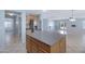 Bright kitchen featuring wooden cabinets, gray countertops, a center island, that opens to the living room at 43232 W Magnolia Rd, Maricopa, AZ 85138