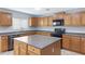 Bright kitchen featuring wooden cabinets, gray countertops, a center island, and modern appliances at 43232 W Magnolia Rd, Maricopa, AZ 85138