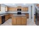 Spacious kitchen with wooden cabinets, center island, gray countertops, and stainless steel appliances at 43232 W Magnolia Rd, Maricopa, AZ 85138