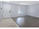 Inviting living room featuring sleek, gray flooring and a bright window at 43232 W Magnolia Rd, Maricopa, AZ 85138