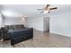 Open living area features a large TV, a sectional sofa, and ceiling fans at 43232 W Magnolia Rd, Maricopa, AZ 85138