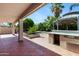 View of the covered outdoor kitchen and patio area with nice desert landscaping at 43232 W Magnolia Rd, Maricopa, AZ 85138