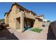 Exterior view of a home features a covered patio, rock landscape, and small patch of green grass at 5323 E Hopi Ave, Mesa, AZ 85206