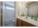 Bathroom featuring wood cabinet, single sink, and view into bath and toilet area at 5323 E Hopi Ave, Mesa, AZ 85206