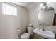 Neat half bath with pedestal sink and round mirror at 5323 E Hopi Ave, Mesa, AZ 85206