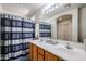 A bathroom with a double sink vanity, a large mirror, and a shower with a blue striped curtain at 5323 E Hopi Ave, Mesa, AZ 85206
