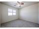 A bright bedroom with carpet, neutral walls, and a ceiling fan at 5323 E Hopi Ave, Mesa, AZ 85206