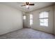A bright bedroom with carpet, a ceiling fan, natural light, and neutral walls at 5323 E Hopi Ave, Mesa, AZ 85206
