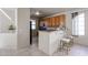 Well-lit kitchen featuring classic wood cabinets, sleek black appliances, and a breakfast bar with seating at 5323 E Hopi Ave, Mesa, AZ 85206