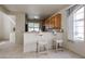 Bright kitchen with a breakfast bar, tile floors, and plenty of natural light streaming through a large window at 5323 E Hopi Ave, Mesa, AZ 85206