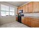 Efficient kitchen layout featuring oak cabinets, a black stove and microwave, and a window providing natural light at 5323 E Hopi Ave, Mesa, AZ 85206
