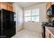 Spacious kitchen area featuring a black refrigerator, oak cabinets, and a bright window above the stove at 5323 E Hopi Ave, Mesa, AZ 85206