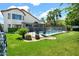 Well-maintained backyard with green grass, palm trees, lush bushes, a pool, and views of the house at 5406 E Charleston Ave, Scottsdale, AZ 85254