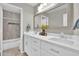Bright bathroom featuring double sinks, white cabinets, quartz counters, a large mirror, and tiled shower-tub combo at 5406 E Charleston Ave, Scottsdale, AZ 85254