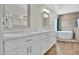 Bathroom featuring dual sinks, white cabinetry, and a soaking tub at 5406 E Charleston Ave, Scottsdale, AZ 85254