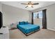 Bedroom featuring a ceiling fan, large window with dark curtains, and bed with blue floral-patterned bedding at 5406 E Charleston Ave, Scottsdale, AZ 85254