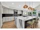 Bright kitchen with a waterfall island, pendant lighting, stainless steel appliances, and barstool seating at 5406 E Charleston Ave, Scottsdale, AZ 85254