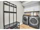 Well-equipped laundry room with modern washer and dryer, storage cabinets, and folding station at 5406 E Charleston Ave, Scottsdale, AZ 85254